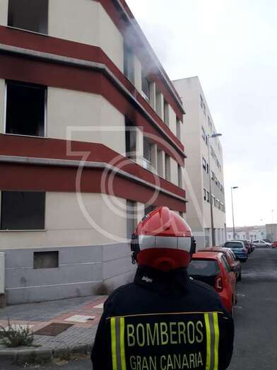 Un bombero observa la humareda que sale por los huecos de la tercera planta (Foto TA)